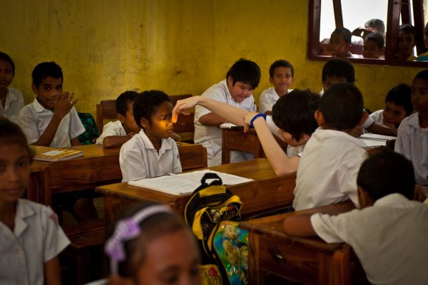 Man at school examining child